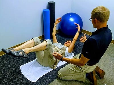 Image of Dr. Lederman chiropractor wheaton instructing a patient through the dead bug exercise